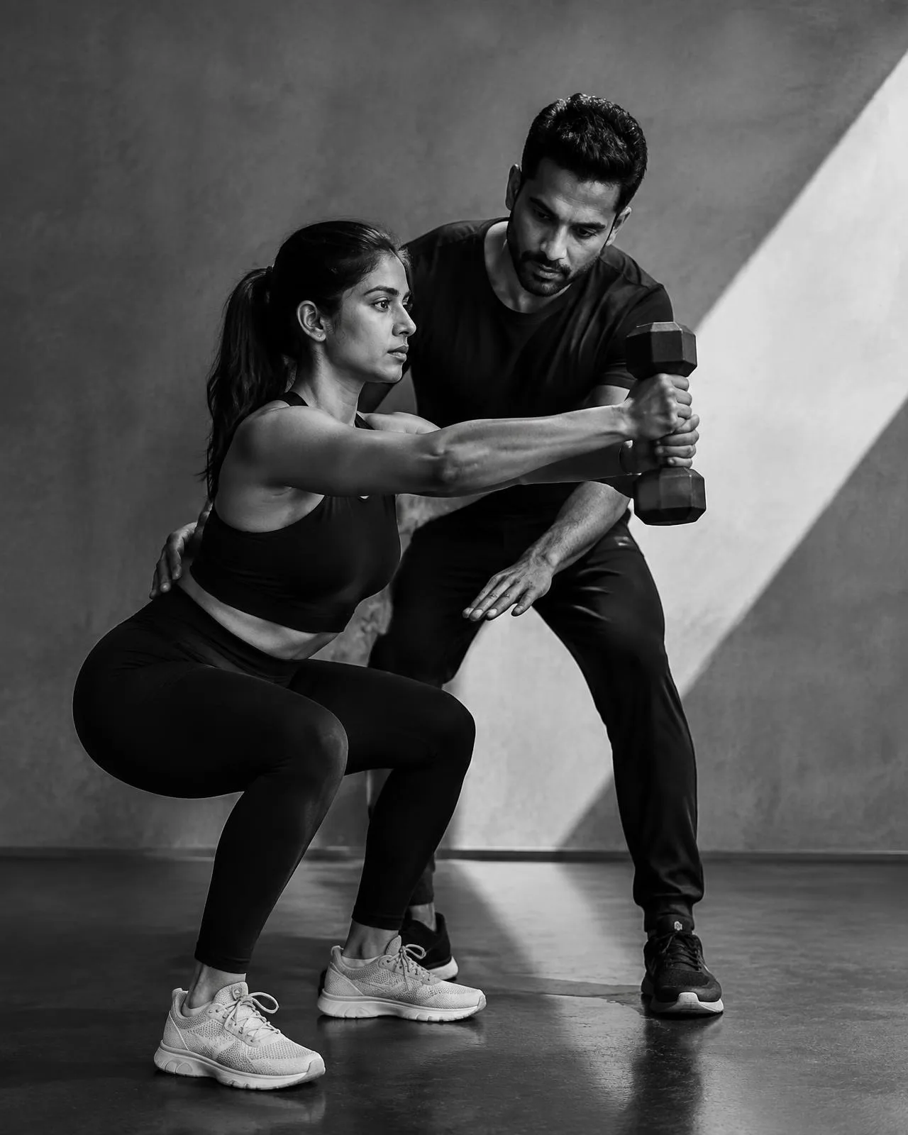 Fitness coach guiding a client through strength training